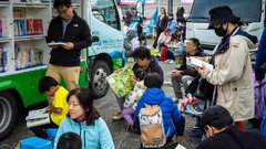 移動図書館の本を読む子どもら＝２０２３年１２月、台北